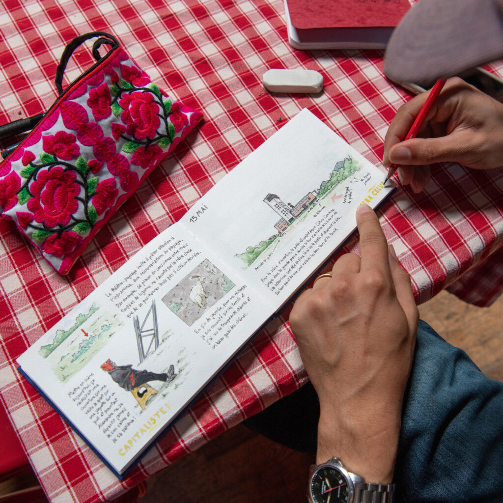 Louis Loup Collet dessine dans le carnet réalisé pour la compagnie Lumière d'Août